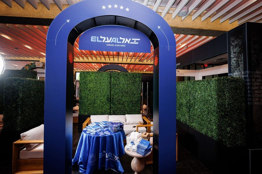 The full El Al Israel Airlines stand — branded arch, hedge walls and lounge seating
